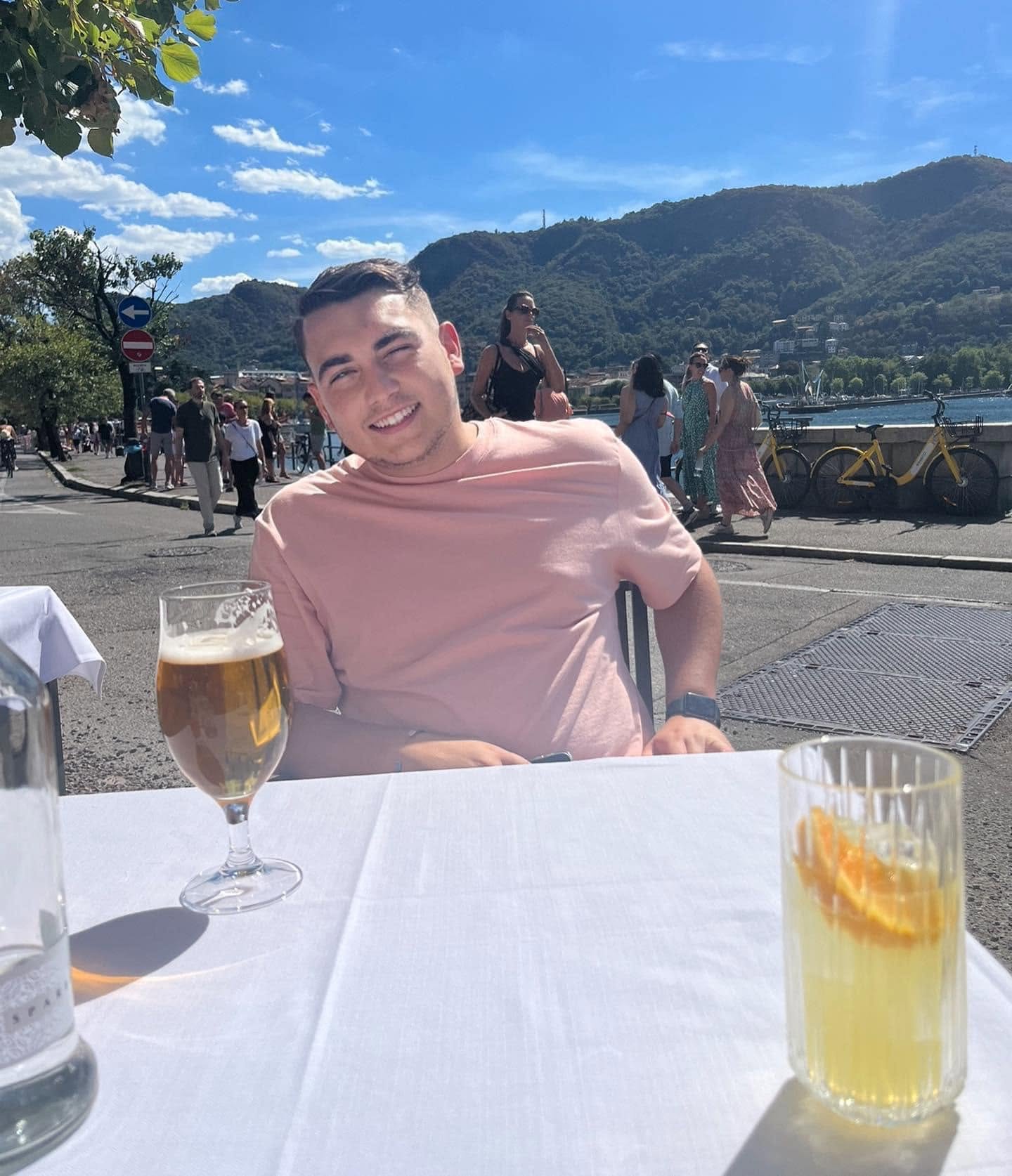 Charlie, smiling at a table by the lakeside on holiday.